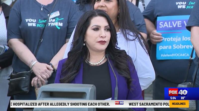 Video still from FOX 40 of Senator Susan Rubio speaking at a press conference alongside advocates holding signs supporting VOCA funding for survivors